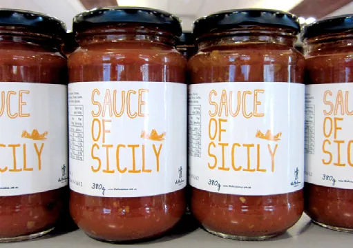 Rows of The Herdsman Sauce of Sicily jars with hand-lettered labels