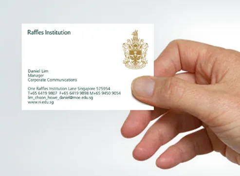 Raffles Institution business card using the green-and-gold crest system