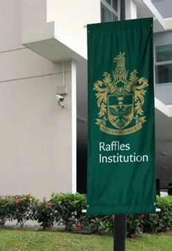 Green Raffles Institution campus banner with the school crest
